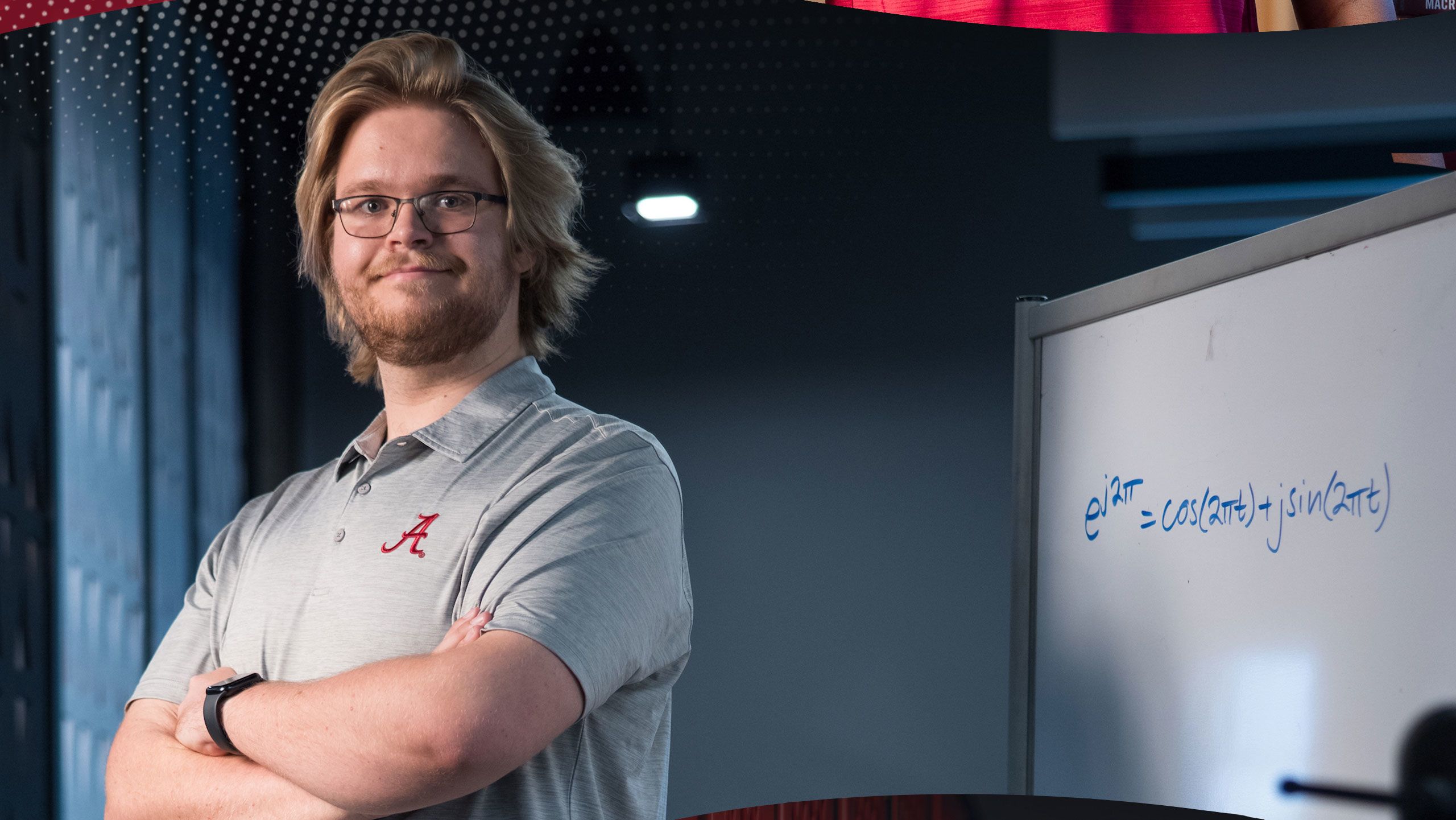 Brodie Alexander posing near a whiteboard in a lab.